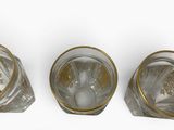 six glasses of water with ice on a white surface