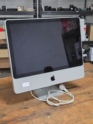 un ordinateur de bureau Apple posé sur une table en bois