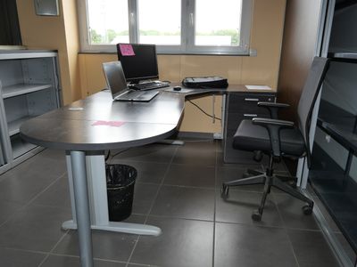 a desk with a laptop on it and a chair in front of it