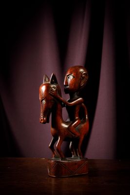 statue of a man riding a horse on a wooden table
