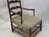 an old wooden chair with a green upholstered seat on a white background