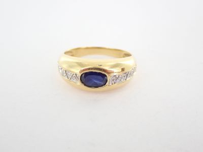 une bague en or jaune sertie d'une pierre bleue et de diamants