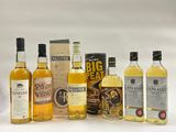 un ensemble de bouteilles contenant différents types d'alcool, posées sur une surface blanche