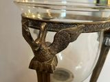 a glass bowl with a bird on it sitting on a table