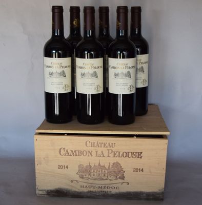 quatre bouteilles de vin rouge dans un coffret en bois posé sur une table