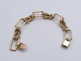 a close up of a gold bracelet with a padlock on it