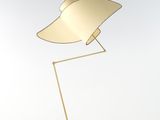 un lampadaire doré avec un pied en bois et un fond blanc