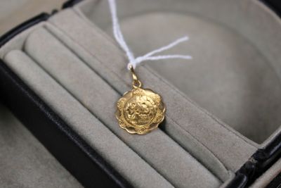a gold coin in a ring box with a white string around it