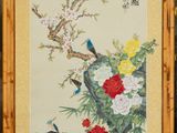 painting of a bird and flowers in a bamboo frame on a wall