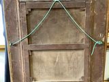 an old wooden picture frame with a rope hanging from it ' s side