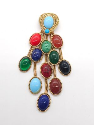 un gros plan d'une broche multicolore posée sur une surface blanche