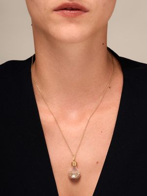 a woman wearing a black shirt and a gold necklace