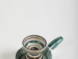 a cup and saucer sitting on a saucer