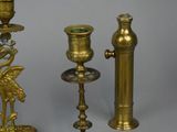 several brass candles and candlesticks on a grey background
