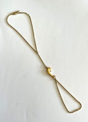 un collier plaqué or orné d'une boule en or suspendue à une chaîne en or