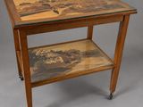 a wooden table with a glass top and a painting on it