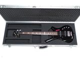 une guitare électrique noire dans un étui, posée sur une surface blanche