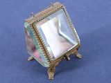 a small mirror sitting on a stand on a blue surface