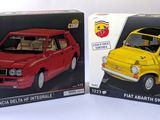 two models of a small car in boxes on a table