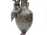 a statue of a woman and a child sitting on a vase