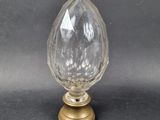 an image of a glass and brass vase on a black background