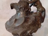 une statue en bronze représentant une femme et un oiseau sur un rocher