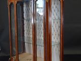 an antique display cabinet with glass doors and gold trimmings