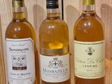three bottles of wine are lined up on a wooden table