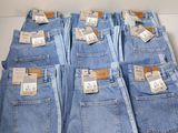 cinq paires de jeans bleus sont empilées les unes sur les autres