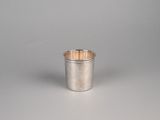 une coupe en argent avec un manche en bois posée sur une surface blanche