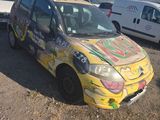 a yellow car that has been painted with graffiti on it