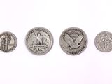 four different types of silver coins on a white surface