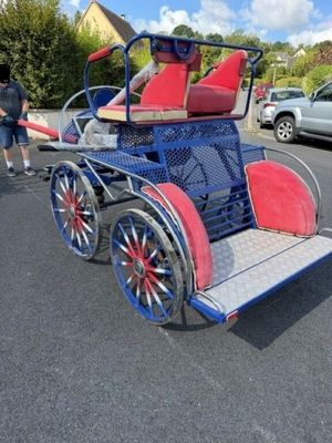 une calèche rouge et bleue avec un siège rouge à l'arrière