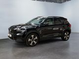 Le SUV noir est garé dans une grande pièce aux murs blancs.