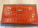 crocodile skin leather wallet on display on wooden table in room