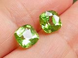 une paire de péridots verts au doigt de quelqu'un