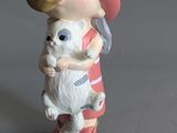 a small figurine of a girl holding a cat