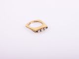 a gold ring with three small diamonds on it
