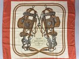 une écharpe orange et blanche sur laquelle sont représentées une paire de bottes d'équitation