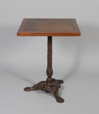 une petite table avec un plateau en bois et des pieds sculptés