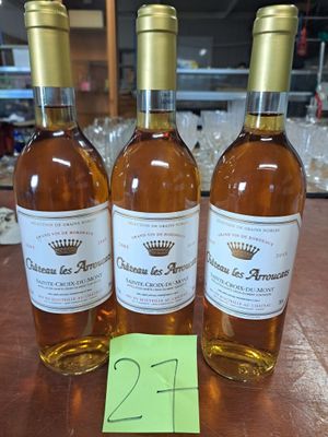 trois bouteilles de vin posées sur une table en bois