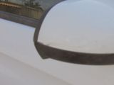 mirror of a white car with a black handle on the side of it