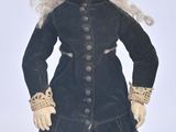 a doll that is wearing a hat and dress