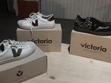 trois paires de chaussures blanches et noires posées sur des cartons