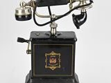 un téléphone à l'ancienne avec un socle noir et des finitions dorées
