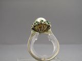 une image représentant une bague en or ornée de pierres vertes