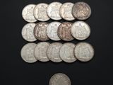 several coins are arranged on a black surface with a coin in the foreground