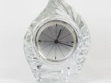 a small crystal clock sitting on top of a white table