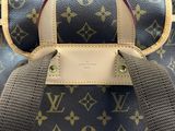 un sac Louis Vuitton bleu et marron posé sur une chaise