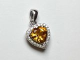 une image représentant un pendentif en citrine et diamants en forme de cœur sur fond blanc